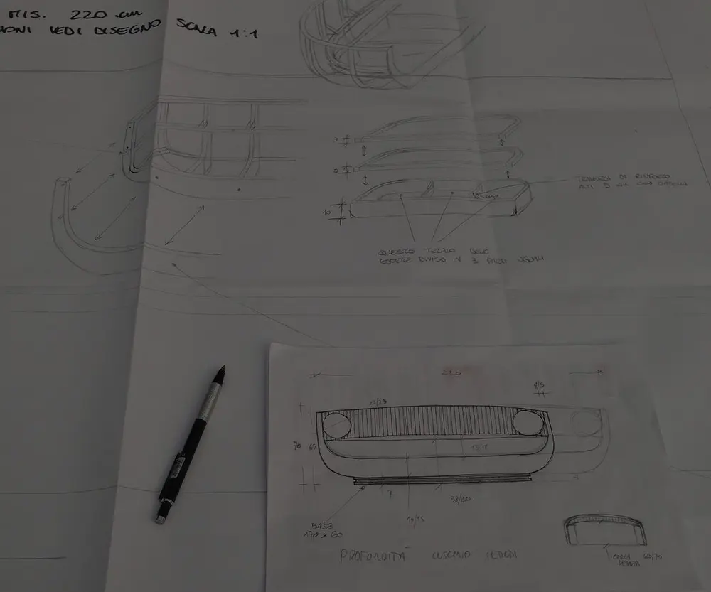 Il disegno a mano di un divano, con le misure e il portamine appoggiato sul foglio