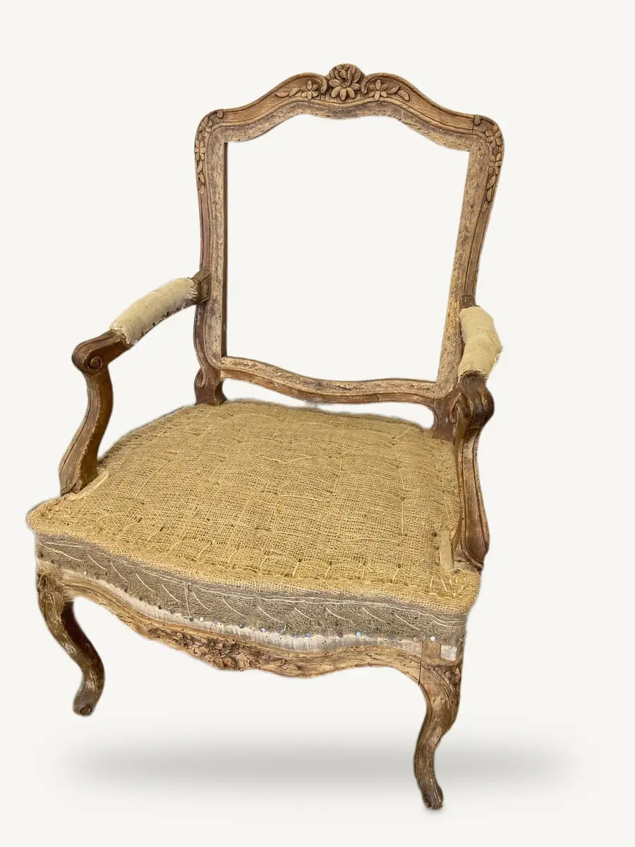 La poltrona con l'imbottitura nuova chiusa nella tela, il bordo cucito a mano e il legno chiaro